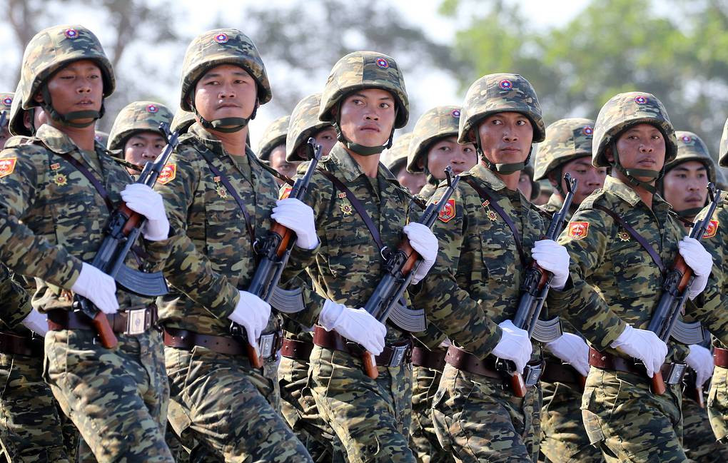 Quân đội Lào cũng vừa cho ra mắt một loại mũ nhựa tương tự mũ A2 của Việt Nam trong cuộc duyệt binh hồi đầu năm 2019 vừa qua. Ảnh: Khối chiến sĩ Lào với súng tiểu liên Type-56 báng gấp và mũ nhựa kiểu mới.