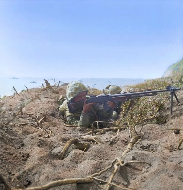 Tại núi Zhebo, lính Nhật ẩn nấp trong cỏ, đá, dưới lòng đất và hang động đã sử dụng nhiều loại súng máy, súng cối và pháo binh để ngăn chặn quyết liệt quân Mỹ. Trong ba giờ đầu tiên, hơn 2.000 binh lính Mỹ đã bị thương vong; đây là số thương vong lớn nhất của Quân đội Mỹ trong Thế chiến 2, chỉ sau cuộc đổ bộ Normandy. Ảnh: Quân Mỹ chiến đấu trên đảo Iwo Jima - Nguồn: Wikipedia