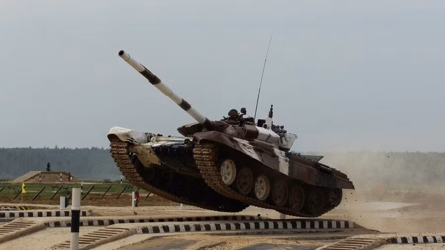 Xe tăng T-72B4 với việc tăng công suất động cơ đáng kể, bên cạnh kính ngắm ảnh nhiệt Sosna-U, còn trang bị thêm cả kính ngắm toàn cảnh cho trưởng xe, tấm thép che kính Sosna-U có thể đóng mở từ trong xe chứ không cần kíp lái phải tháo ra thủ công như các xe đời trước. Ảnh: Xe tăng T-72B3 vượt vật cản trong cuộc thi Tank Biathlon - Nguồn: Wkipedia.