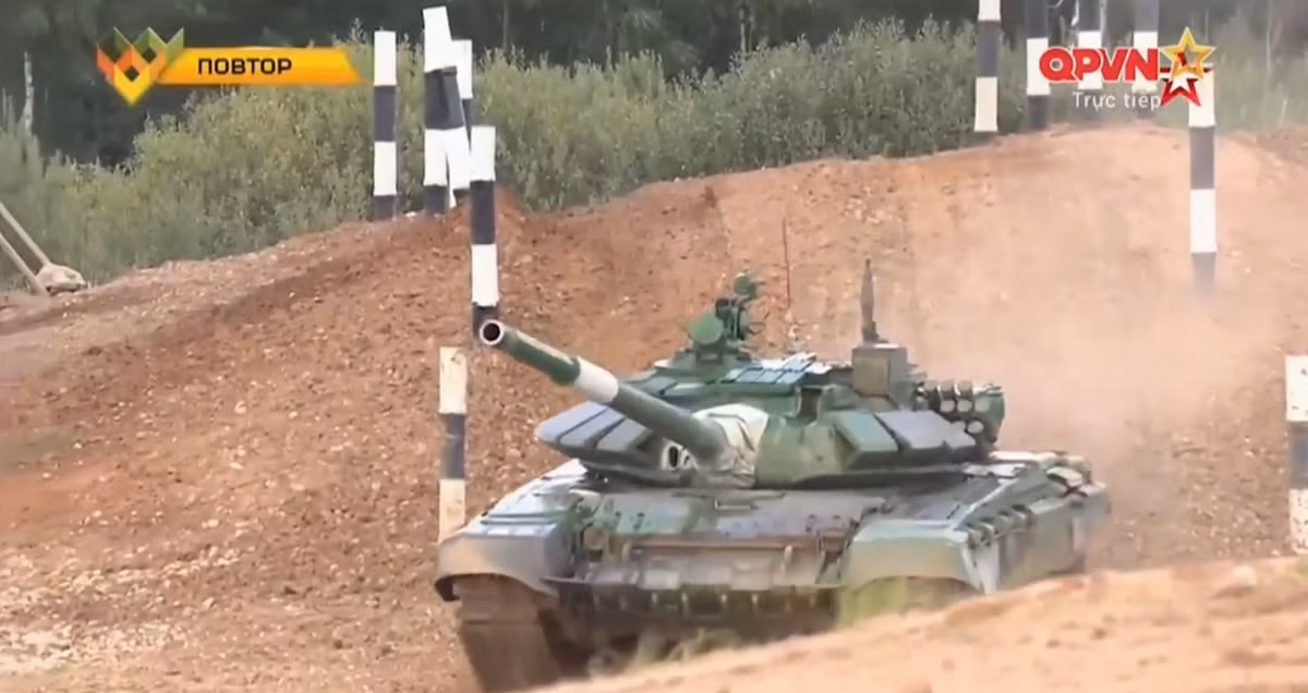 Trình độ sử dụng khí tài của kíp xe Myanmar vẫn còn nhiều nhược điểm, có thể ví dụ như cách họ tác xạ bài súng máy 12.7mm của trưởng xe. Khi ngắm bắn mục tiêu bằng súng máy 12.7mm, trưởng xe chỉ sử dụng khe ngắm cơ khí mà không sử dụng kính ngắm quang học được cấp phát khiến cho hiệu quả tác chiến là vô cùng thấp. Đây là thực tế xuất phát từ việc Myanmar trong nước chỉ có xe tăng T72S phiên bản cũ hơn, vốn dĩ không có nhiều trang bị mới như trên T72B3 khiến đội bạn có phần bỡ ngỡ. Ảnh: Xe tăng đội Myanmar cơ động vượt dốc nghiêng mái nhà.