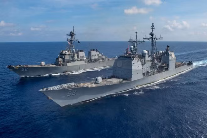 Một số quốc gia đứng đầu là Mỹ cho rằng, các thủ đoạn tuần tra trên biển, bồi đắp trái phép các đảo đá và bố trí các loại vũ khí tiến công ở khu vực Biển Đông, đã phá hoại hiện trạng vùng Biển Đông, khiến tranh chấp trên Biển Đông ngày một leo thang, Mỹ cần phải liên kết với các nước liên quan để gia tăng phản đối. Ảnh: Tàu tuần dương USS Bunker Hill (phải) và khu trục hạm USS Barry đi qua Biển Đông ngày 18/4.