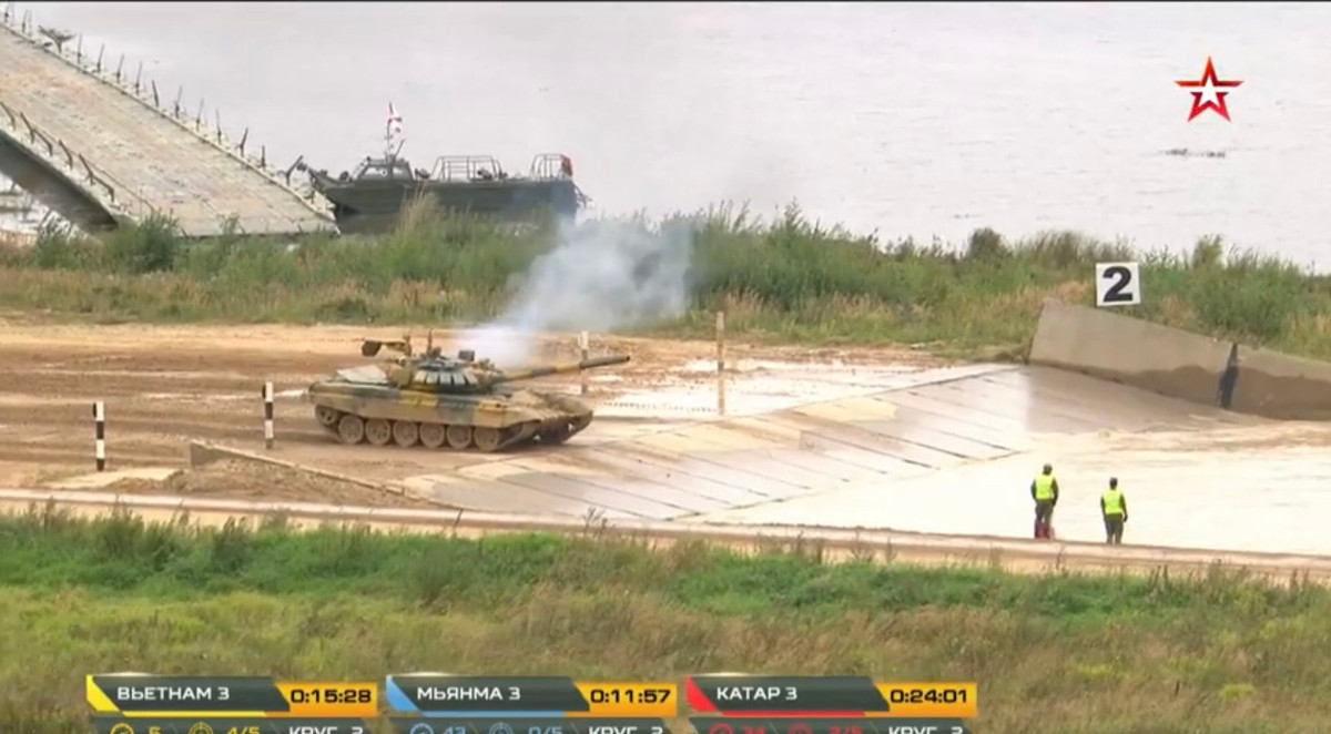 Tuy vậy, một sự cố cực kỳ không may đã xảy ra, sau đoạn đường thẳng cơ động với tốc độ cao, xe tăng Việt Nam đã gặp trục trặc kỹ thuật, động cơ bốc khói dữ dội và đã không thể di chuyển được nữa, dừng lại ngay phía trước hào nước tại vòng đua thứ hai. Ảnh: Xe tăng Việt Nam bốc khói, bất động ngay trước hào nước của vòng chạy thứ hai.