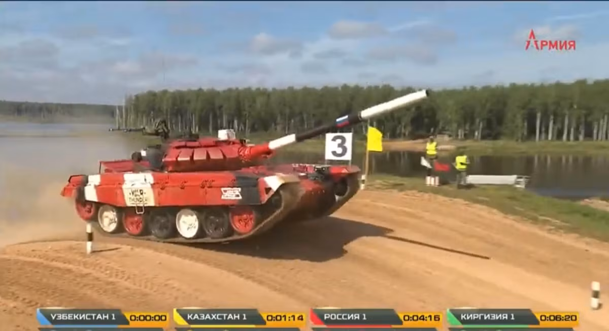 Lái xe của kíp lái số 1 đội tuyển Nga đã điều khiển xe vô cùng hiệu quả, đạt tốc độ cao và nhanh chóng vượt qua tất cả các loại vật cản, chứng ngại vật trên thao trường và không hề đâm đổ cọc tiêu nào. Ảnh: Xe tăng Nga vượt dốc nghiêng với tốc độ cao.