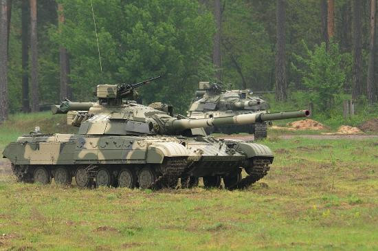 Tuy nhiên với sự ra đời của xe tăng chiến đấu chủ lực “con cưng” T-64, người Liên Xô đã có một cuộc cách mạng trong việc bố trí súng máy phòng không 12.7mm trên xe tăng. Người lính đã không còn phải trực tiếp trèo ra ngoài xe tác xạ như trước mà trưởng xa có thể khai hỏa súng từ trong xe thông qua các cơ cấu cò. Ảnh: Xe tăng T-64 của quân đội Ukraine, súng máy 12.7mm có thể được điều khiển từ trong xe.