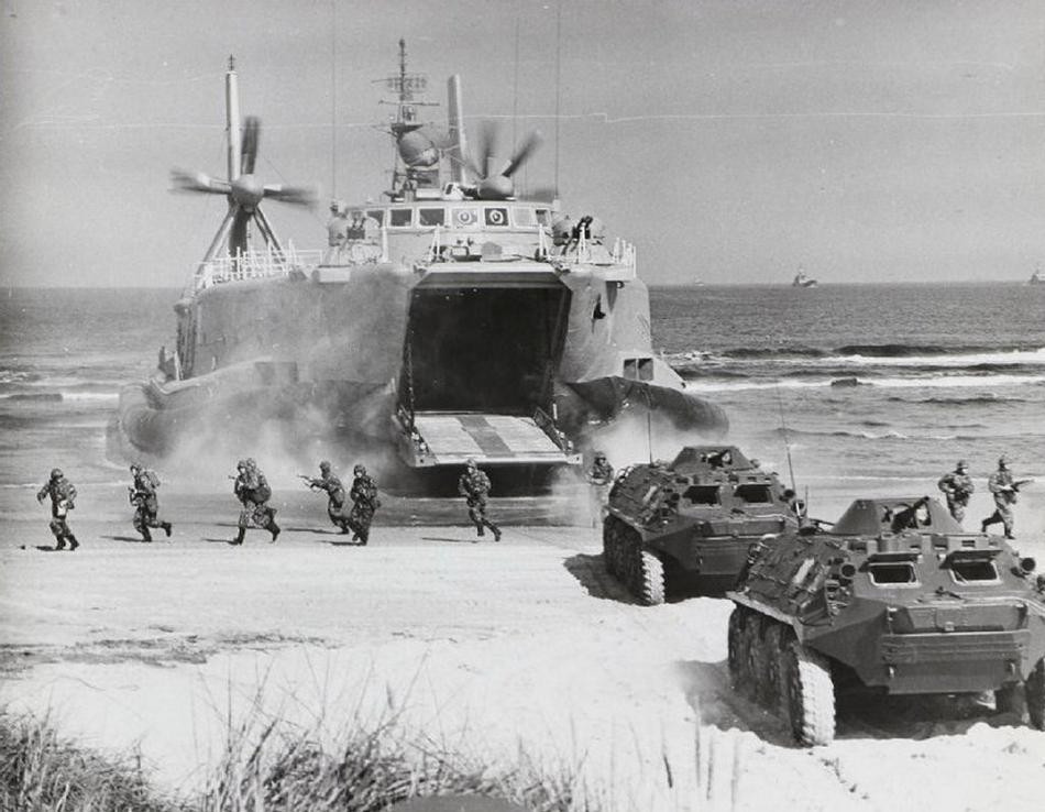 Trong năm 1980, tàu đổ bộ Aist đã thực hiện nhiệm vụ cơ động lực lượng bao gồm cả binh sĩ, xe bọc thép và xe tăng hạng nhẹ đổ bộ lên bãi biển của Đông Đức trong khuôn khổ cuộc diễn tập chung của các quân đội thuộc khối Waszawa. Đây là một hình ảnh cực kỳ đặc biệt và hiếm hoi, không nhiều người có thể biết về việc đây chính là lớp tàu đổ bộ đệm khí đầu tiên được Hải quân Liên Xô sử dụng. Ảnh: Cơ động phương tiện và người từ trong tàu Aist xuống bãi biển của Đông Đức.
