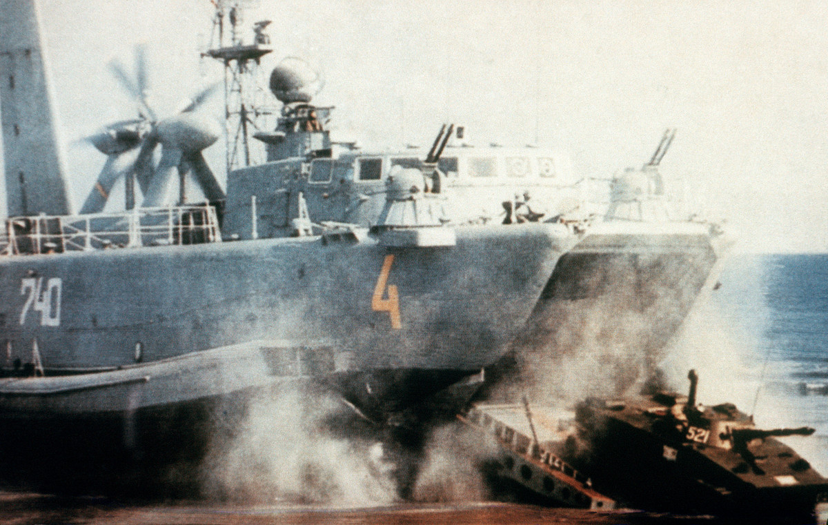 Về vũ trang, tàu trang bị 2 hệ thống pháo cao tốc AK-230 cỡ 30mm được dẫn bắn bởi radar kiểm soát hỏa lực MR-104 Drum Tilt nhằm chống lại các mục tiêu mặt biển cỡ nhỏ cũng như máy bay, trực thăng bay thấp, ngoài ra một số lượng tàu còn được trang bị thêm giá phóng tên lửa phòng không vác vai tầm thấp Strela-2 cho nhiệm vụ bảo vệ tàu khỏi các mối đe dọa từ trên không trung. Ảnh: Xe tăng hạng nhẹ PT-76 đổ bộ ra từ khoang tàu Aist.