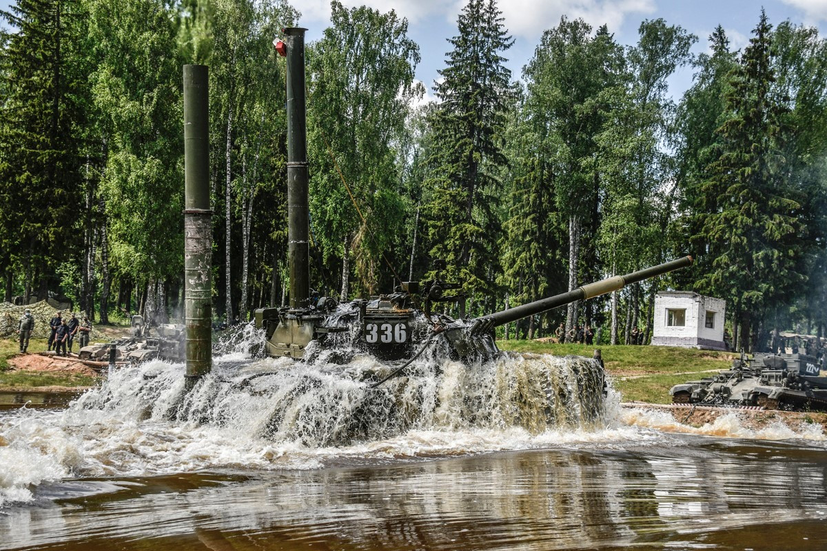 Việc huấn luyện xe tăng vượt sông luôn tiềm ẩn nguy hiểm do cũng như rủi ro cao nếu không chuẩn bị kỹ càng hoặc kíp lái thiếu kinh nghiệm. Tuy nhiên đây là lại khoa mục bắt buộc của kíp xe bởi nó là những điều kiện thực tế không thể tránh khỏi trên chiến trường. Ảnh: Hai xe cứu kéo BREM đậu trên bờ để sẵn sàng hỗ trợ xe tăng T-80U trong tình huống xấu.