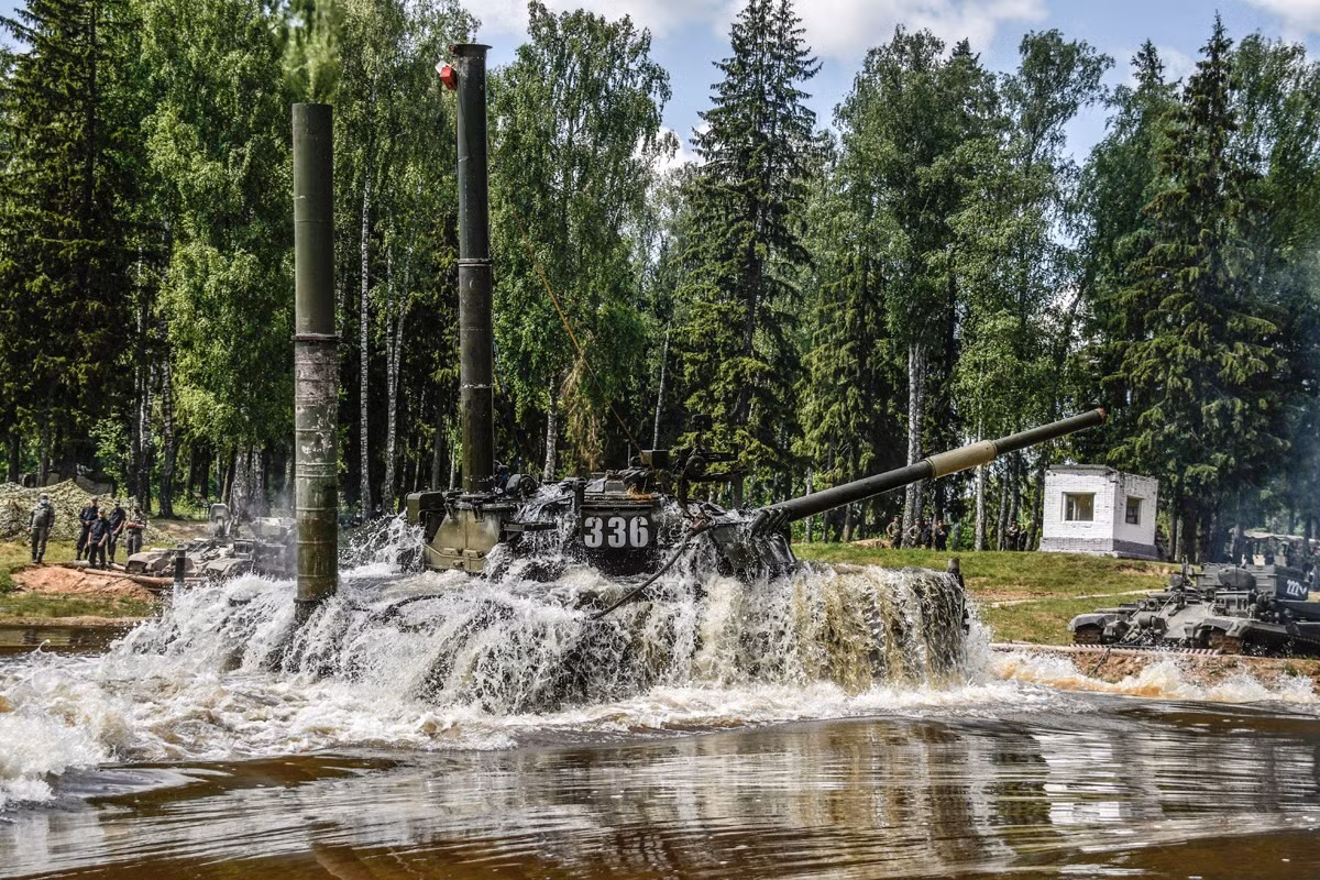 Việc huấn luyện xe tăng vượt sông luôn tiềm ẩn nguy hiểm do cũng như rủi ro cao nếu không chuẩn bị kỹ càng hoặc kíp lái thiếu kinh nghiệm. Tuy nhiên đây là lại khoa mục bắt buộc của kíp xe bởi nó là những điều kiện thực tế không thể tránh khỏi trên chiến trường. Ảnh: Hai xe cứu kéo BREM đậu trên bờ để sẵn sàng hỗ trợ xe tăng T-80U trong tình huống xấu.