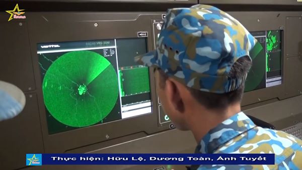 Với kinh phí quốc phòng hạn hẹp, việc chúng ta thay thế toàn bộ các radar cảnh giới 2D bắt thấp dải sóng dm như P-15, P-19 hiện có bằng các loại radar mua mới từ nước ngoài là không khả thi. Thay vào đó, việc tự nghiên cứu chế tạo đài radar 2D sóng dm mới do tập đoàn Viettel thực hiện cho tính năng kỹ thuật tương đương loại radar P-19, tiết kiệm chi phí rất lớn. Ảnh: Trắc thủ vận hành radar VRS-2DM. Có thể thấy radar sử dụng các loại màn hình hiển thị LED rất hiện đại.