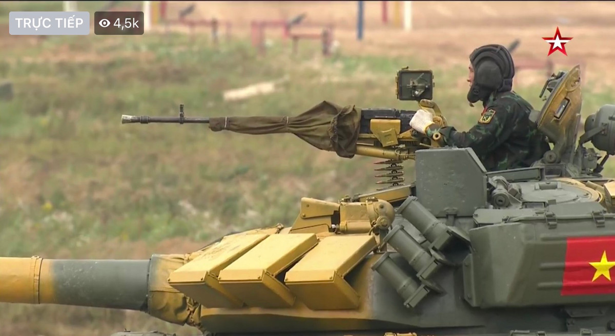 Bước vào vòng thi thứ hai, xe tăng sẽ tiến vào bài bắn tiêu diệt mục tiêu bia số 25 giả định máy bay trực thăng của đối phương bằng súng máy phòng không 12.7mm. Rất thuần thục, xe Việt Nam tiến vào vị trí tiếp nhận đạn với cơ số 15 viên, pháo thủ hỗ trợ nạp đạn vào súng trong thời gian trưởng xe khẩn trương lấy đường ngắm bằng kính ngắm quang học. Ảnh: Trưởng xe kíp lái số 1 Việt Nam lấy đường ngắm cho súng máy phòng không 12.7mm.