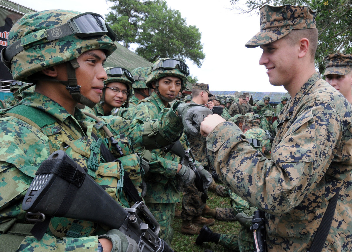 Dù là một quốc gia nhỏ bé nhưng với tiềm lực kinh tế phát triển, Brunei cực kỳ chú trọng đầu tư trang bị cho chiến sĩ một cách tối đa, trong đó cũng không thể không kể đến trang bị quân phục dã chiến. Brinei sử dụng quân phục ngụy trang họa tiết nhỏ màu tím than, nâu và xanh nhạt phối hợp trên nền xanh đậm truyền thống tạo tính thích nghi tốt với môi trường. Ảnh: Binh sĩ Brunei (trái) giao lưu với binh sĩ Mỹ (phải).