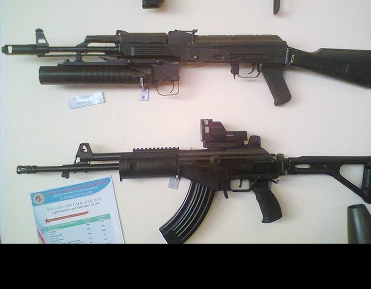 Nắp hộp khóa nòng có các gờ nổi tương tự với nắp hộp khóa nòng của AKM, súng bổ sung một chụp bù giật đầu nòng kiểu AK-74 và một gá đa năng ở bên trái thân súng để có thể gắn các loại kính ngắm quang học, kính nhìn đêm, kính ngắm điểm đỏ,… Ốp lót tay được chế tác tinh tế với các gờ nổi để xạ thủ có thể bám chắc vào súng trong quá trình tác xạ, đồng thời có các ray Picatinny ở dưới để có thể gắn súng phóng lựu kẹp nòng, tay cầm phụ hoặc càng chống. Ảnh: Súng AK-103 do Việt Nam chế tạo (trên) và Galil Ace 32 (dưới).