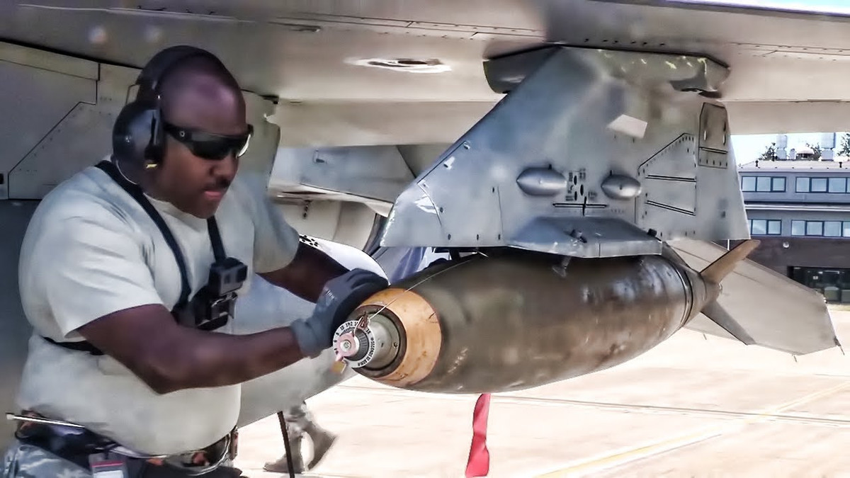 Bom Mk-82 của Mỹ có hình dạng thuôn, dài 2.22m, đường kính 273mm, vỏ làm bằng thép và đầu nổ chứa 87kg thuốc nổ Tritonal (một loại thuốc nổ có sức công phá mạnh hơn TNT). Ảnh: Binh sĩ Mỹ kiểm tra một quả bom Mk-82 dưới cánh tiêm kích F-16.