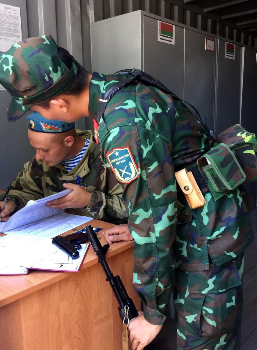 Bên cạnh những vũ khí tiêu chuẩn do nước chủ nhà Belarus cung cấp, các chiến sĩ Việt Nam cũng được trang bị thêm túi đựng đạn - súng ngắn chuyên dụng dành cho Đội tuyển bắn súng quân dụng Việt Nam do đoàn ta tự mang trong nước đi, nhằm nâng cao khả năng tác chiến của chiến sĩ cũng như sự quen thuộc đối với trang bị. Ảnh: Chiến sĩ Việt Nam đăng ký tiếp nhận vũ khí với cán bộ Belarus.