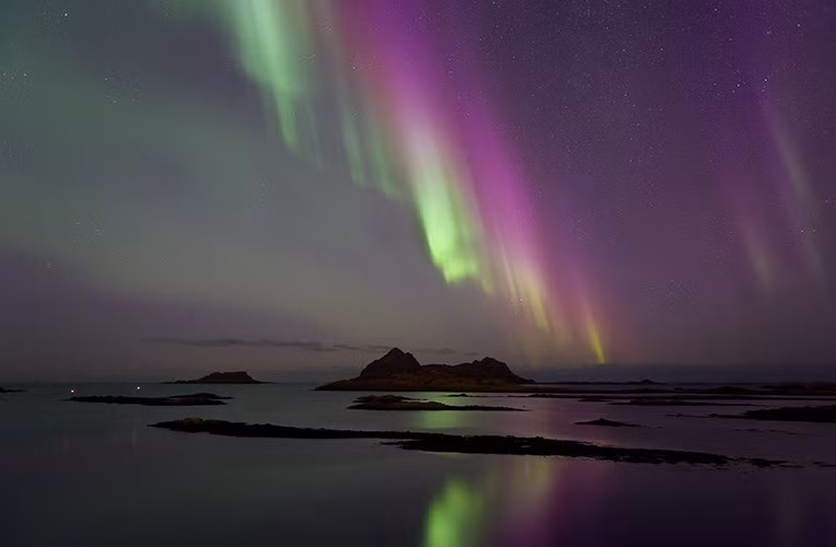 Kết quả là cực quang phát ra ánh sáng hồng cẩm cực hiếm gặp khi các hạt tích điện đập vào các nguyên tử nitơ.