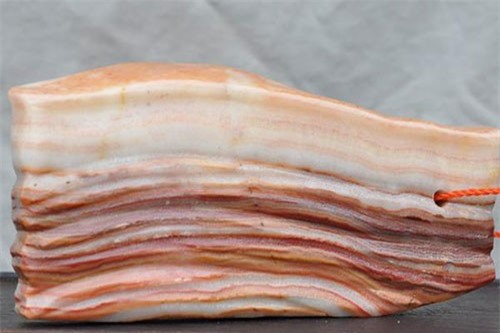 Viên đá này có kích thước vừa phải, vẻ bề ngoài giống hệt một miếng thịt ba chỉ, với những tầng trắng, nâu phân định rõ rệt cùng bề mặt căng bóng như miếng bì lợn.