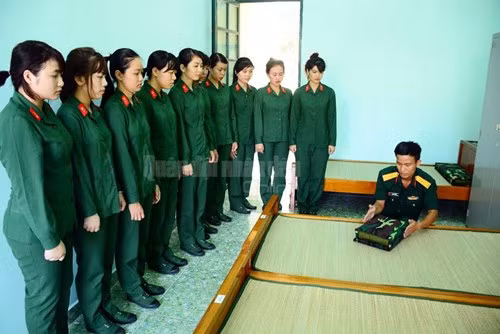 Cán bộ trung đội hướng dẫn nữ chiến sĩ tân binh gấp chăn màn. Ảnh: QĐND.
