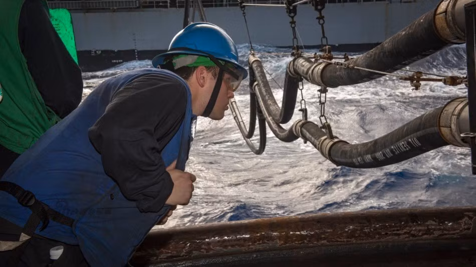 Công việc đòi hỏi sự phối hợp ăn ý giữa các bên, thông tin liên lạc phải được thông suốt, các kỹ sư cần theo dõi hệ thống kết nối liên tục để điều chỉnh khoảng cách giữa hai tàu, đảm bảo chúng vẫn chạy song song chứ không phải đang tách xa dần nhau. Ảnh: Một kỹ sư kiểm tra độ võng của dây cáp để chắc chắn hai con tàu vẫn đang chạy song song nhau, nếu có bất cứ sai sót nào họ sẽ báo hiệu để thuyền trưởng 2 tàu chỉnh lại hướng di chuyển ngay lập tức. Nguồn ảnh: Sina.