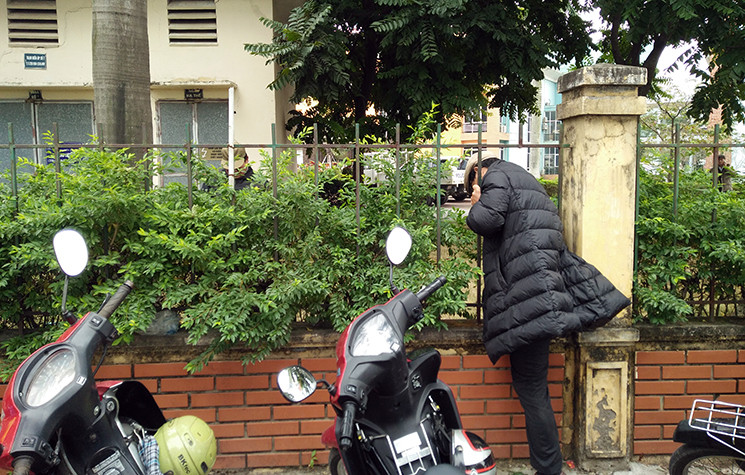 Một số người hâm mộ chui qua khe hàng rào sắt để vào phía bên trong trụ sở VFF.