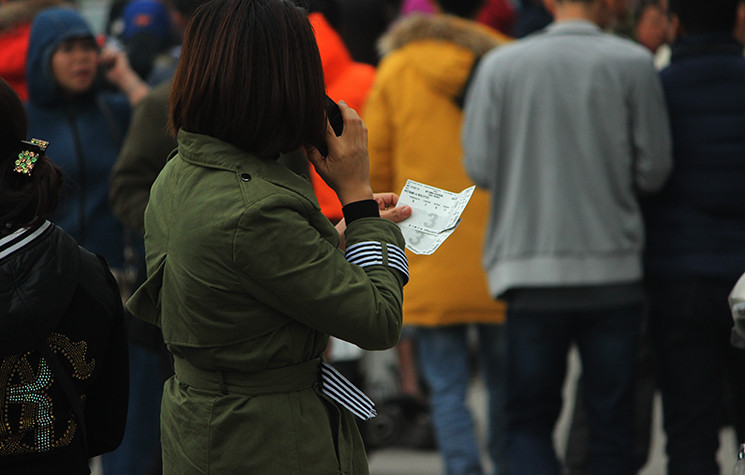 Một người hâm mộ gọi điện thông báo cho người thân biết mua được cặp vé chợ đen do không thể mua được vé online của VFF.