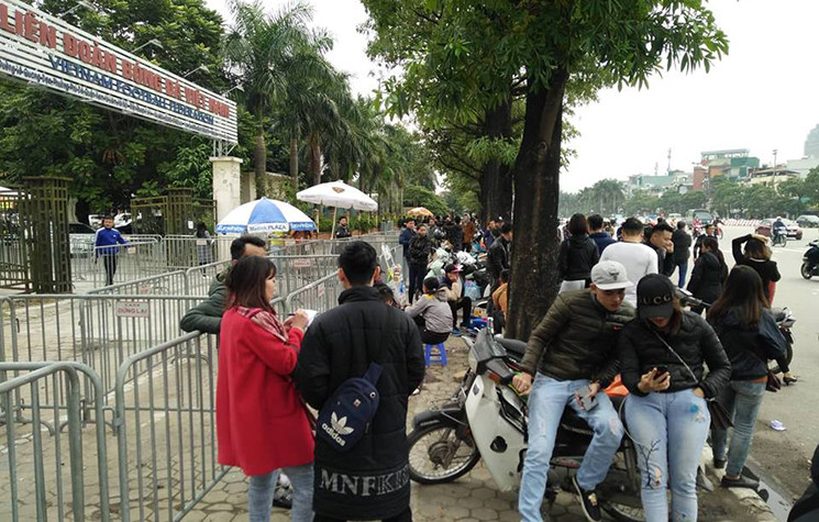 Một phe vé (áo đỏ) tỏ ra thận trọng, cô này ghi lại thông tin, số điện thoại của người hâm mộ có nhu cầu mua vé, sau đó sẽ tiến hành giao dịch nơi khác vì lo sợ cảnh sát bắt giữ.