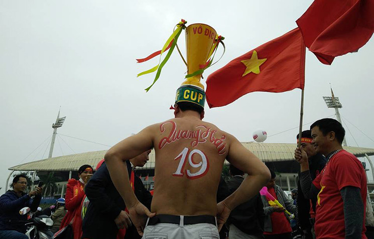 Dù thời tiết ở Hà Nội lúc này đang là 19 độ C, nhưng không khí tại sân Mỹ Đình đang rất nóng. Bởi vậy, cổ động viên cũng quên đi cái lạnh. Hình ảnh một cổ động viên không còn cảm giác lạnh, cởi áo in hẳn số áo cầu thủ Quang Hải lên mình để cổ vũ cho đội tuyển Việt Nam.