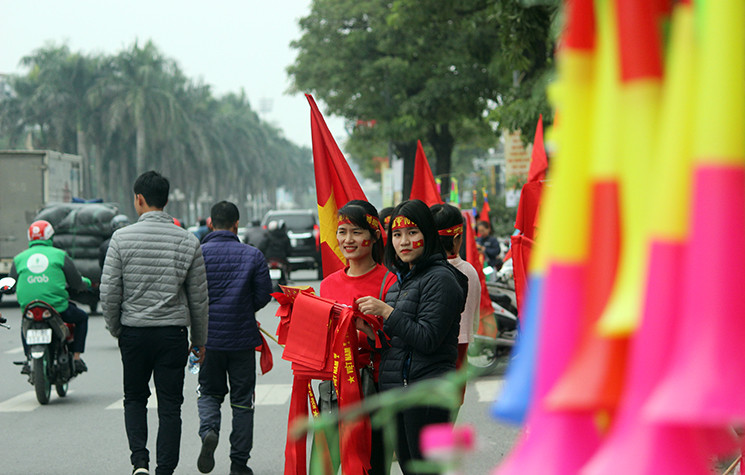 Trong khi đó, khắp các ngả đường của Hà Nội cờ đỏ sao vàng, băng rôn, kèn cổ vũ được bày bán náo nhiệt.