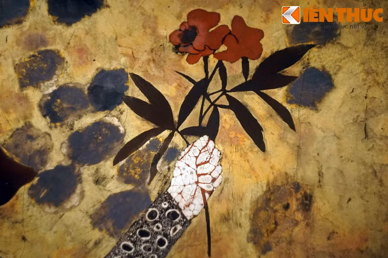 Trên tay một bé gái cầm cành hoa đỏ.