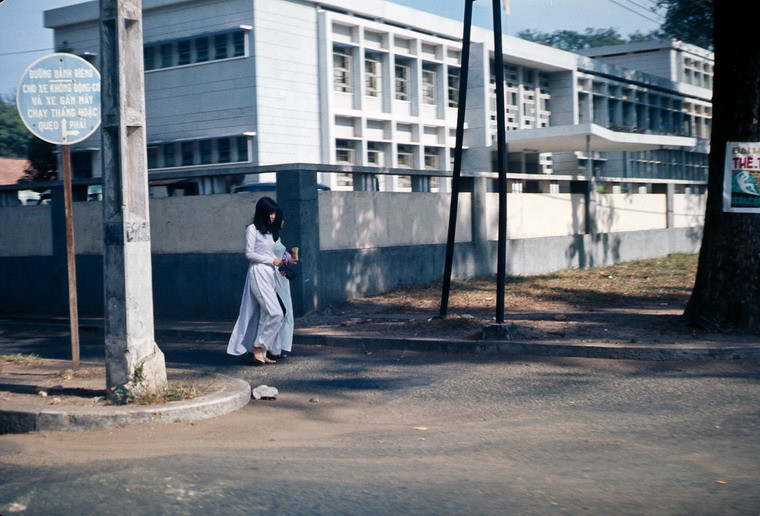 Hai thiếu nữ áo dài bước đi phía ngoài trụ sở Bộ Ngoại giao.