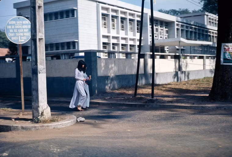 Hai thiếu nữ áo dài bước đi phía ngoài trụ sở Bộ Ngoại giao.