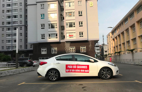 Một hộ dân đã tận dụng chiếc ôtô của mình đậu dưới sân khu căn hộ để giăng băng rôn phản đối chủ đầu tư.