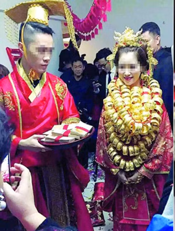 Một đám cưới tổ chức tại Quảng Đông (Trung Quốc) đã thu hút sự chú ý của nhiều người khi chú rể cải trang thành Hoàng đế đầu đội mũ vàng, còn cô dâu cũng không kém cạnh khi vàng treo "gãy" cổ. Tiền mừng cưới cũng như quà cưới của quan khách chỉ có thể bày hết lên bàn và tràn sang cả sofa.