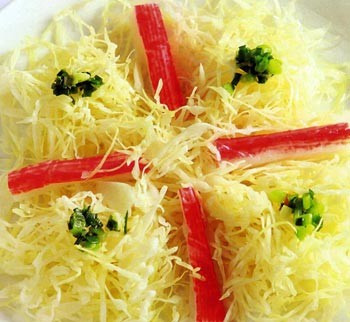 Bắp cải xào thanh cua: Bắp cải bào thành sợi nhuyễn, ngâm rửa sạch với nước muối pha loãng, vớt ra, để ráo. Thanh cua Nhật rửa sạch luộc chín. Phi thơm tỏi băm với 2 thìa súp dầu ăn. Cho bắp cải vào xào, sau đó, cho thanh cua vào xào thêm 3 phút, tắt bếp. Ảnh: Dinhduong.