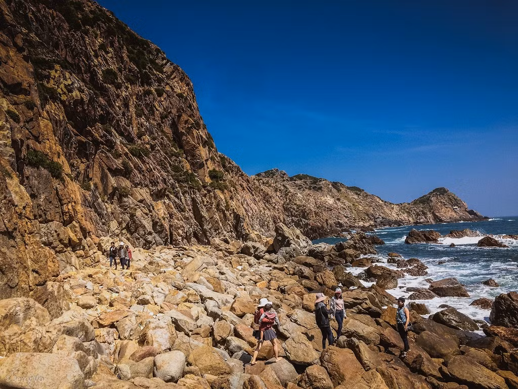 Dưới chân là bãi đá Đẻ, những viên đá được sóng biển bào mòn với nhiều màu sắc và kích thước, tạo nên một bãi biển độc đáo. Chọn một tảng đá bằng phẳng, ngồi nghỉ chân, thả hồn vào biển xanh với những cơn gió mát lành sẽ khiến cho tâm hồn bạn trở nên thanh thản hơn bao giờ hết.