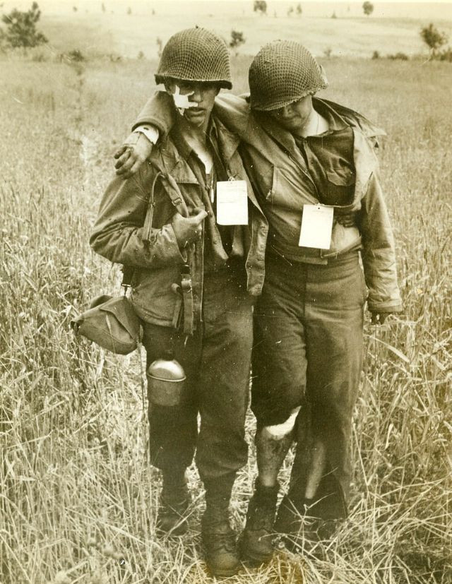 Hai lính Mỹ bị thương dìu nhau đến chỗ tập hợp quân. Ảnh chụp ở Rome hồi Thế chiến 2.