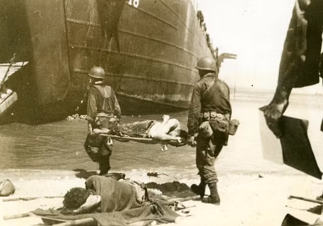 Lính Mỹ khiêng cáng đưa đồng đội bị thương lên tàu đến nơi điều trị.