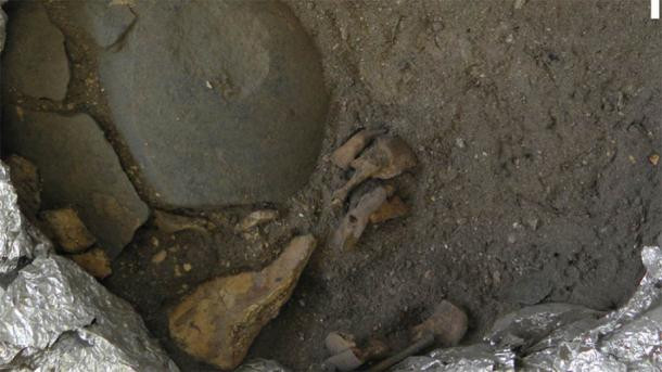 Các chuyên gia phát hiện trên má và trán của đứa trẻ được thoa bột màu đất. Thêm nữa, một viên đá cuội được đặt dưới đầu đứa trẻ.