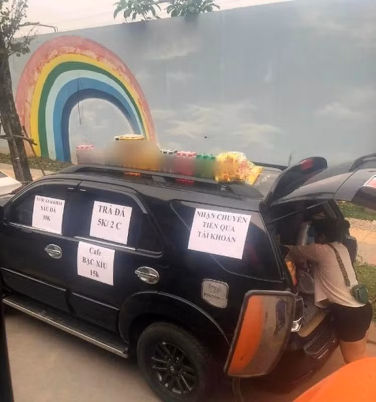 Người phụ nũ bán trà đá này bày bán trên chiếc xe Fortuner Toyota. Chị tận dụng phần nóc xe ô tô để bày những loại nước uống cho mọi người dễ thấy và lựa chọn. Còn riêng phần cốp xe được sử dụng để bày phích nước, cốc chén, chai lọ,…