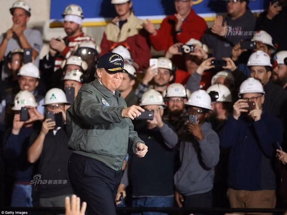 Ông Donald Trump vui vẻ chụp ảnh lưu niệm và giao lưu với các thủy thủ ngay dưới boong tàu. Nguồn ảnh: Sina.