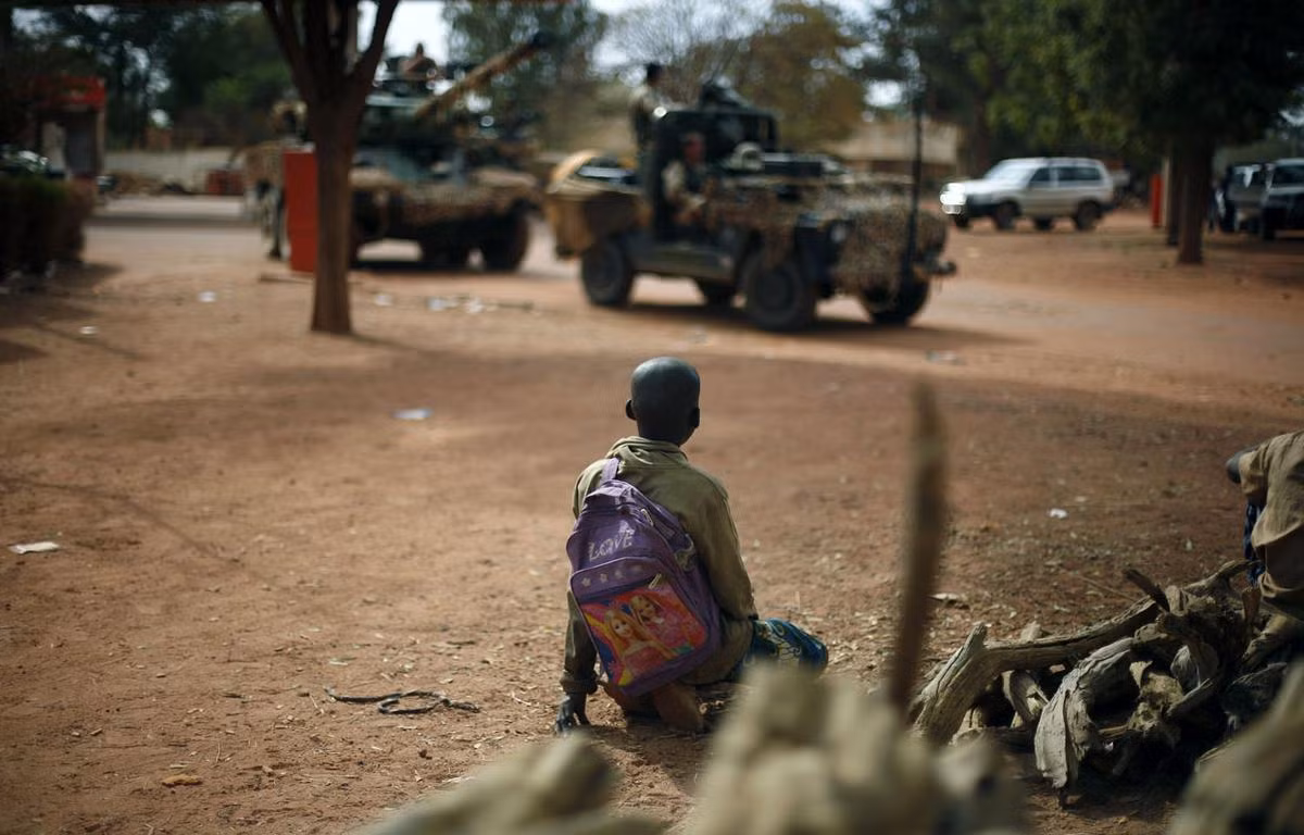 Những đứa trẻ Mali đi học trên cùng một con đường mà lực lượng viễn chinh di chuyển quân mỗi ngày. Các cuộc xung đột ở châu Phi thường diễn ra ngay giữa các khu dân cư đang sinh sống khiến cho số lượng dân thường bị thiệt mạng oan trong các cuộc giao tranh là rất lớn. Nguồn ảnh: Theatlantic.