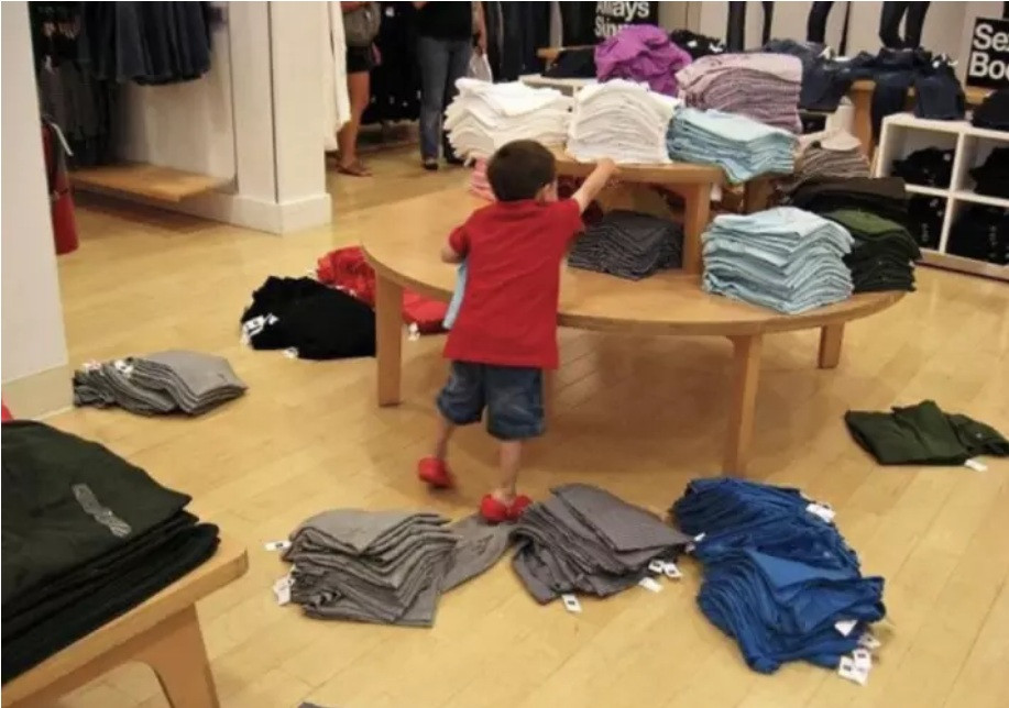 Trong khi bố/mẹ đang đi thử đồ thì cục cưng lại bày trò nghịch như này tại cửa hàng bán quần áo.