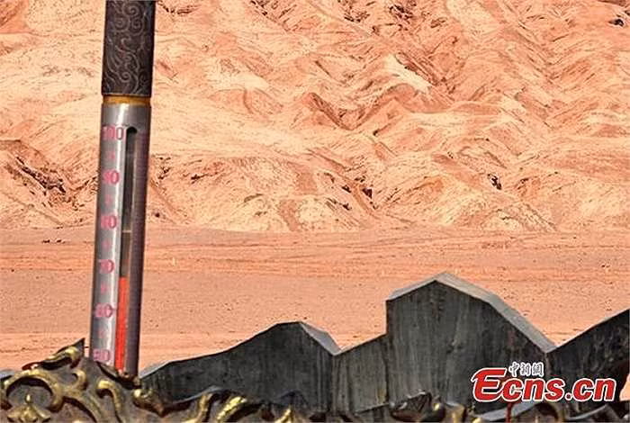 Dụng cụ để đo nhiệt độ ở một trong những nơi nóng nhất Trái Đất này là chiếc nhiệt kế khổng lồ dựng gần dãy núi. Cơ quan khí tượng địa phương đã nâng mức cảnh báo nắng nóng, nhiệt cao lên màu cam và kêu gọi du khách hãy cẩn trọng.