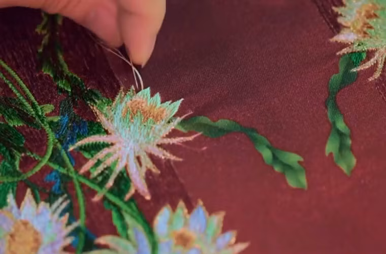 Các họa tiết hoa quỳnh, hoa sen, được thêu tay tỉ mỉ trên phượng bào.