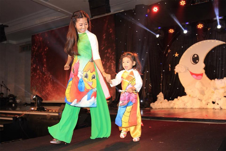 Hai mẹ con Lavie tươi cười trên sân khấu trong một sự kiện.