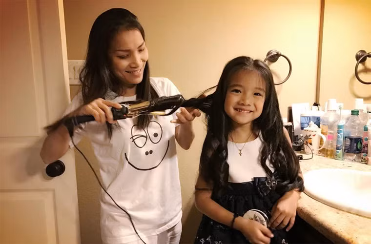 Hồng Ngọc đang tạo kiểu tóc cho con gái Hồng Ân. Cô chăm sóc các con rất kỹ càng.