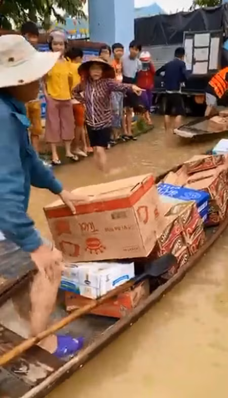 Đồ cứu trợ gồm mì tôm, nước, thuốc và các nhu yếu phẩm được đoàn của Thủy Tiên dỡ từ xe ô tô xuống ghe để đưa vào cứu trợ những người đang mắc kẹt vì lũ.