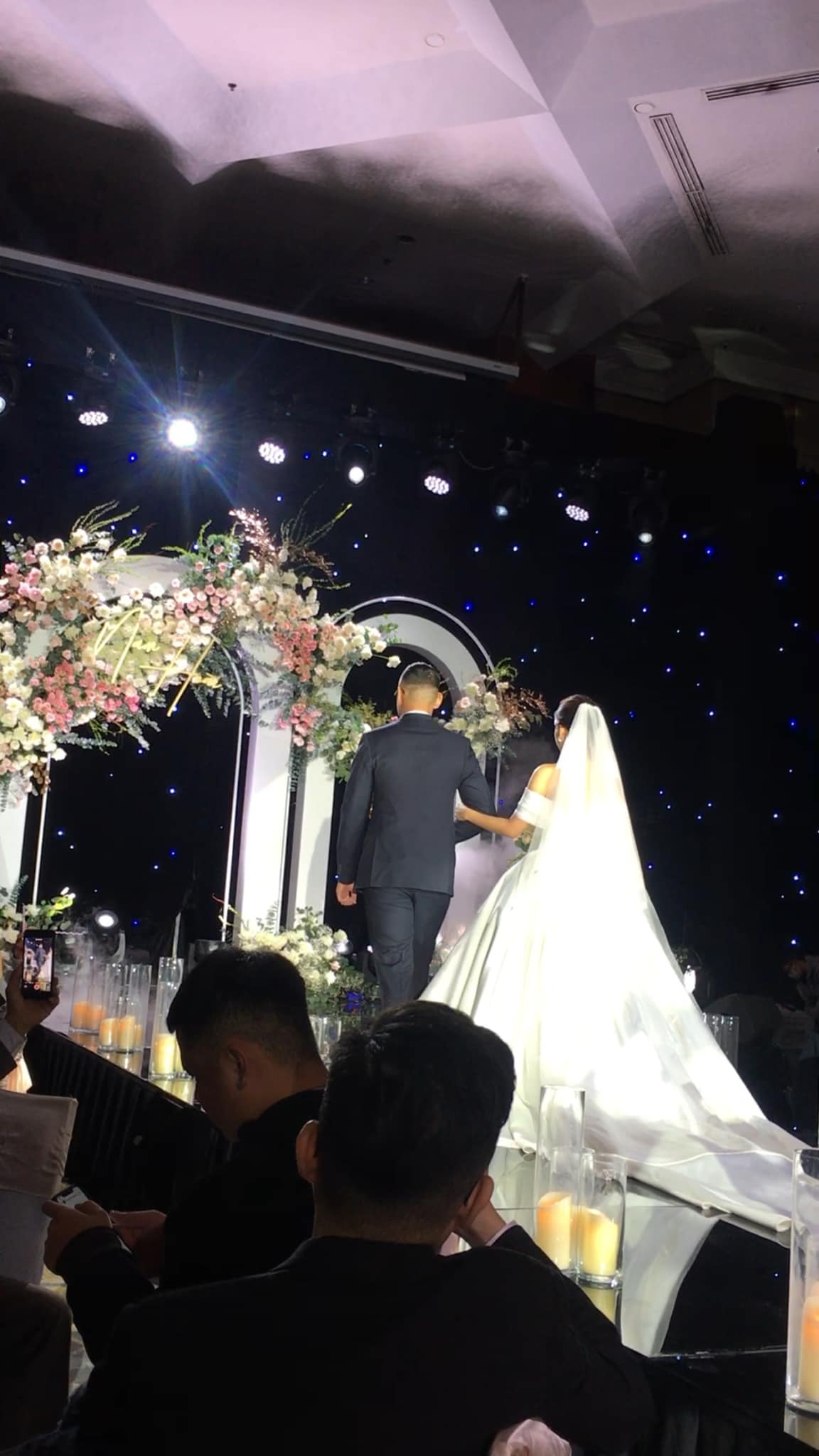 Cô dâu khoác tay chú rể bước vào lễ đường.