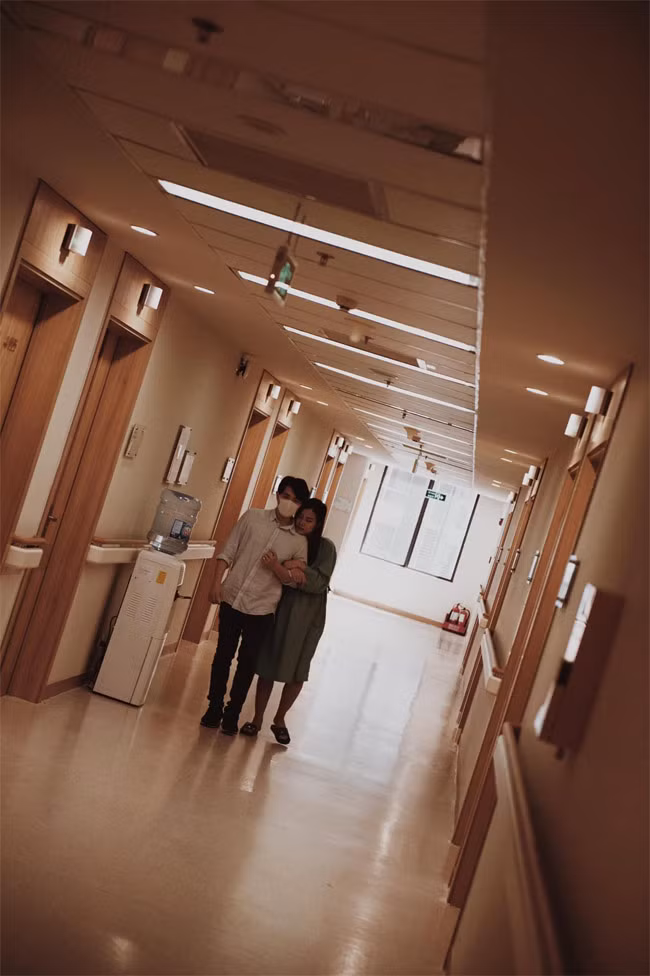 Nam ca sĩ dìu vợ đi lại dọc hành lang để cô dễ đẻ.