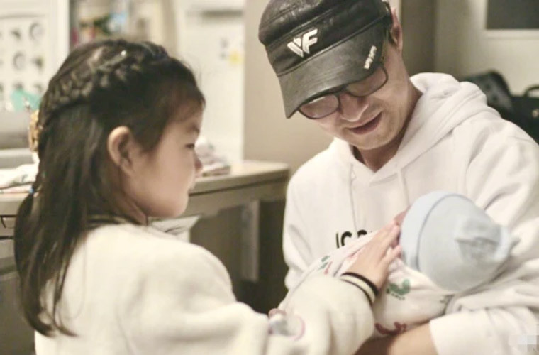 Uông Phong, chồng Chương Tử Di bế con trai mới sinh cho con gái xem mặt.