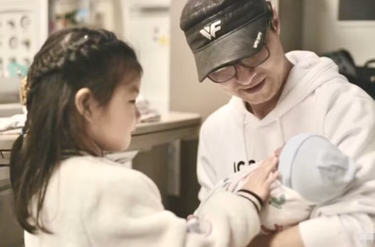 Uông Phong, chồng Chương Tử Di bế con trai mới sinh cho con gái xem mặt.